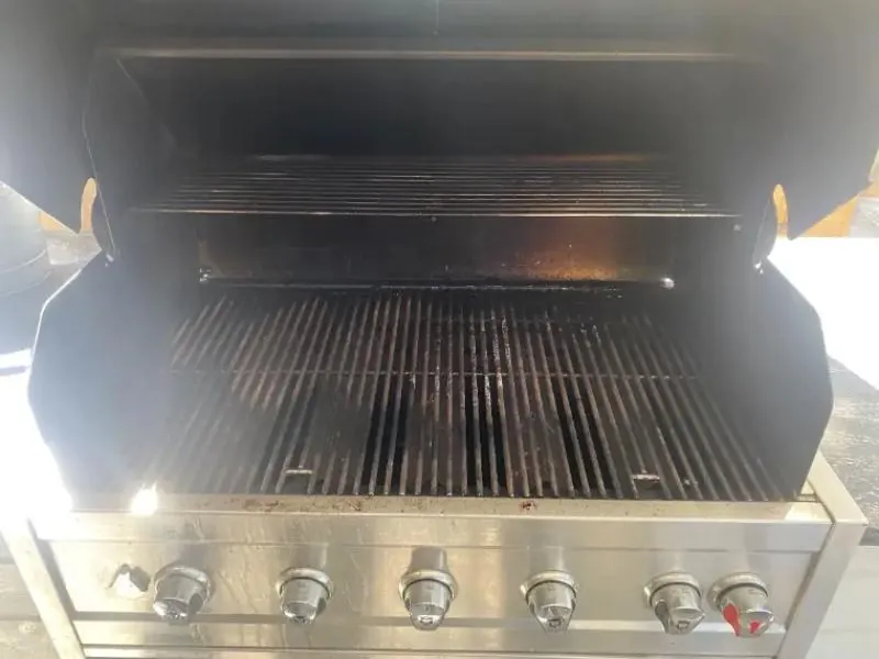 Gas BBQ before cleaning with grease and carbon inside the lid